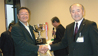 木村町長から祝福される村松さん（左）