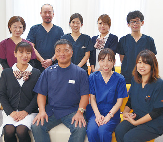 患者やその家族の目線に立って、きめ細やかな応対を心掛けている吉田院長（前列中央左）とスタッフ