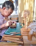 作業場で神輿の部品を彫る山崎さん