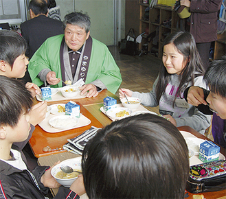 楽しそうに会話をしながら給食を食べる児童と井澤さん