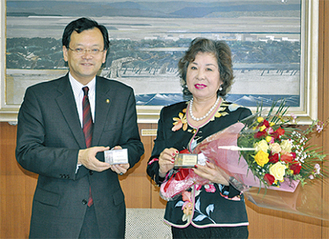 岩崎氏（右）に落合市長が花束と名刺を渡し、任務を託した