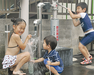 防災井戸での水遊びに歓声を上げる子どもたち