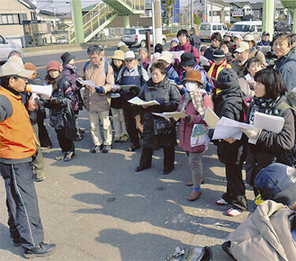 大勢が参加したウォーキングツアー。ガイドを担当しているのは柳川さん（写真左）