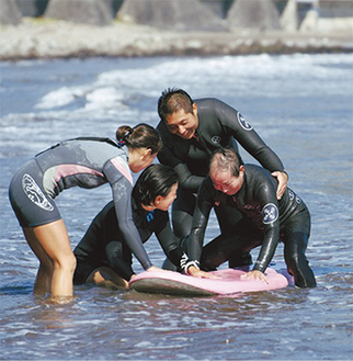 それぞれの技能と知識を生かし、障害を持つ人でも安全にサーフィンを楽しめるサポートをしている