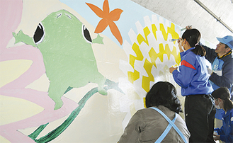 地下道の壁に絵を描く岡崎地区の住民たち