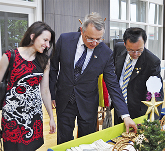 伝統工芸品を手にとる大使（中央）とガリナ夫人（左）