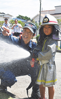 消防士から放水を学ぶ小学生
