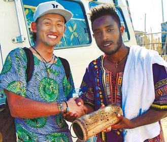 エチオピアにて、バンブーアートを手渡す金子さん（左）と現地で出会った中学校教師の男性