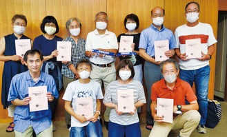 「日本語ボランティア実践ノート」を手にする会員たち