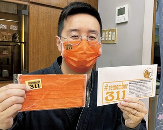 オレンジ色のマスクを紹介する水嶋さん