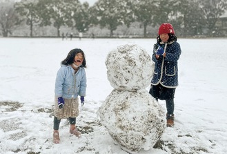 雪だるまを作って楽しむ笑顔の子どもたち