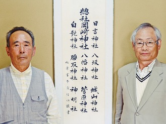 掛軸の前に立つ岡崎神社総代の上原さん（左）と掛軸を発見した佐藤さん
