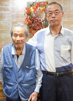 山田軍次さん（左）と長男の周さん