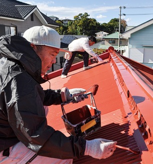 屋根を塗り直す職人たち