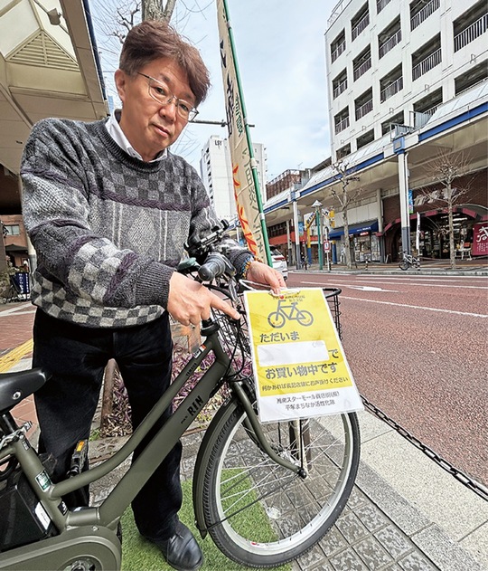 駐輪プレートの説明をする能勢さん