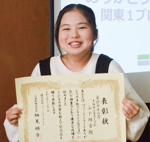 賞状を手に喜ぶ山下さん