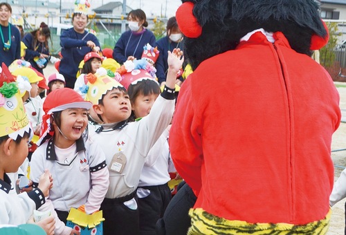 鬼に向かって豆を投げる園児ら