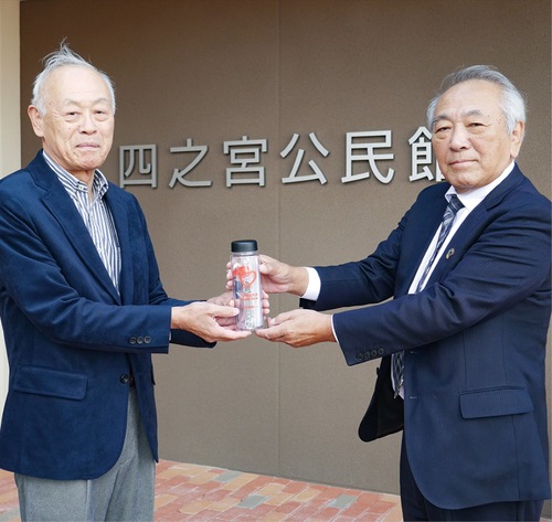 ボトルを手渡す佐藤代表（右）