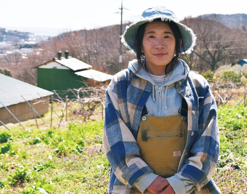 海を望む畑で取材を受ける森山さん