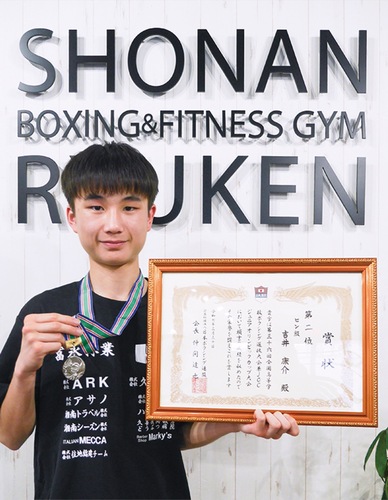 メダルと賞状を持つ吉井さん