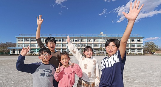 土屋小の校舎と児童（提供写真）