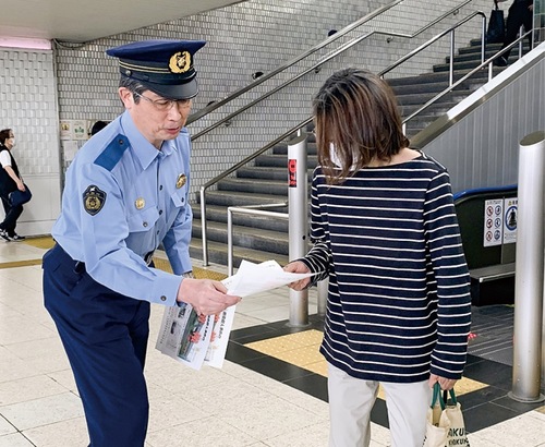 チラシを手渡す石井署長