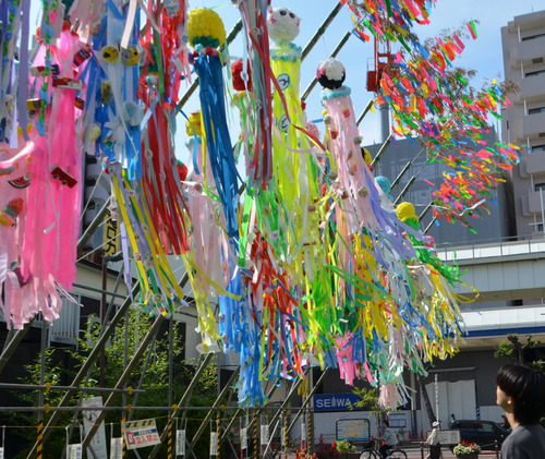 子ども飾りを見上げる通行人