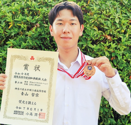 メダルと賞状を持つ青山さん