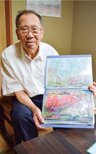 戦争体験を描いた絵を見せる古谷さん