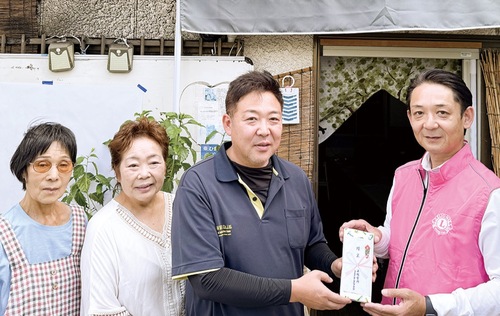 お米券を手渡す曾根田会長（右）