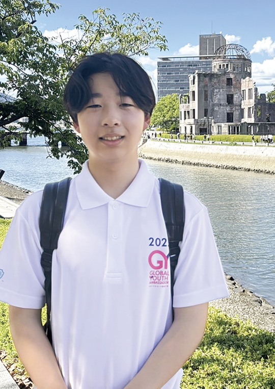 原爆ドームの前に立つ長尾さん（本人提供）