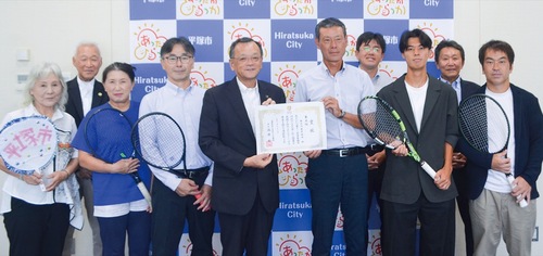 市長表敬した同チームの関係者らと落合市長（中央）