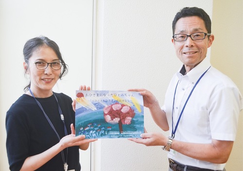 絵本を手渡す三輪先生と和田校長