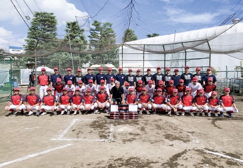 平塚ボーイズに硬球を寄贈した吉川会長（中央）＝同社提供