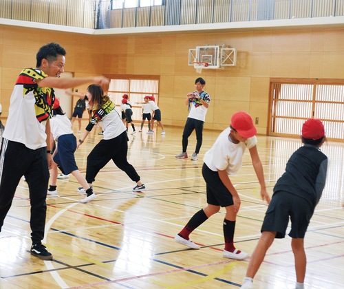 児童と一緒に踊る中込さん（左）