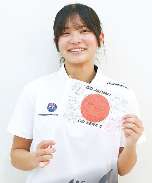 応援メッセージが書かれた国旗を持つ花塚さん