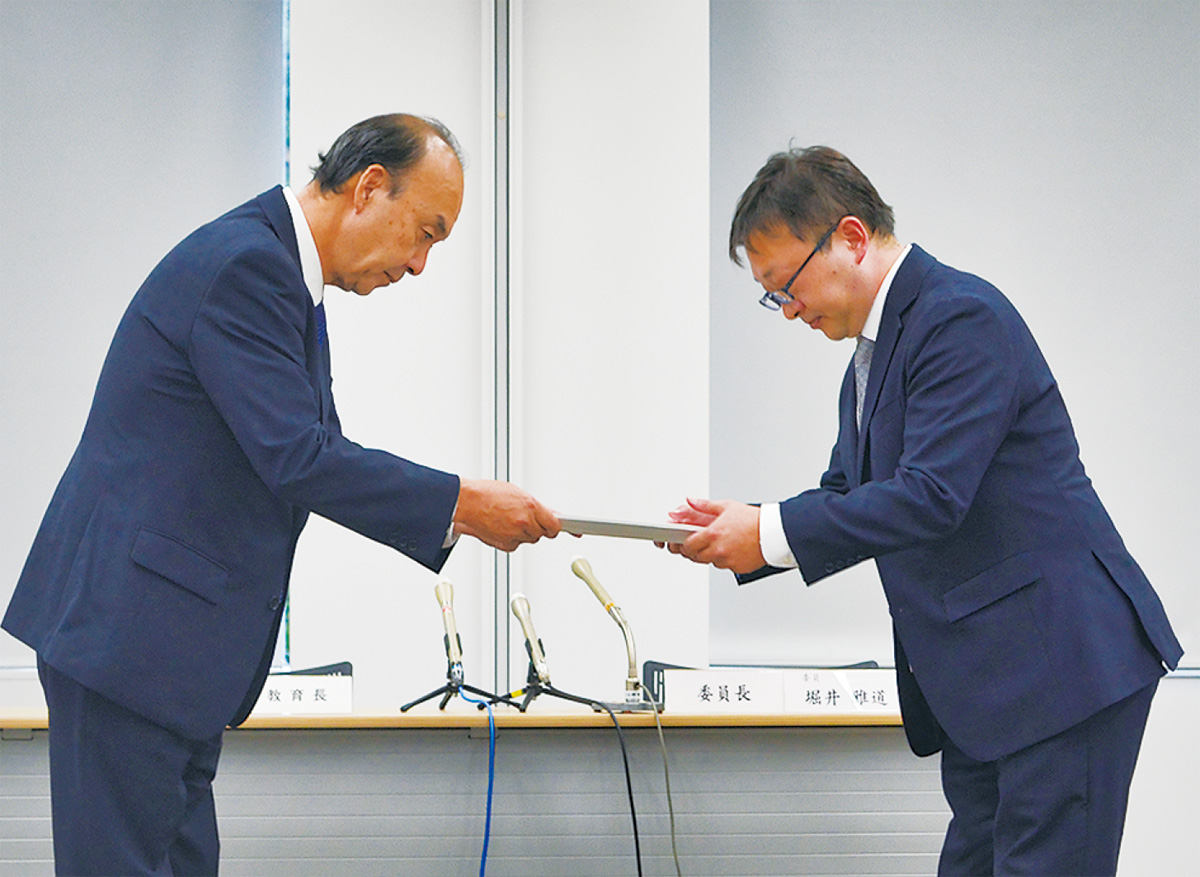 報告書を受け取る吉野教育長(左)