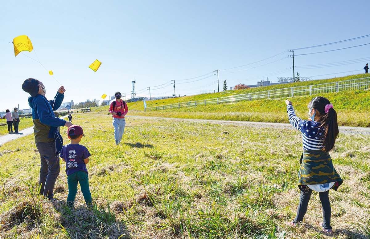 風向きを読み手作りの凧を飛ばす参加者ら