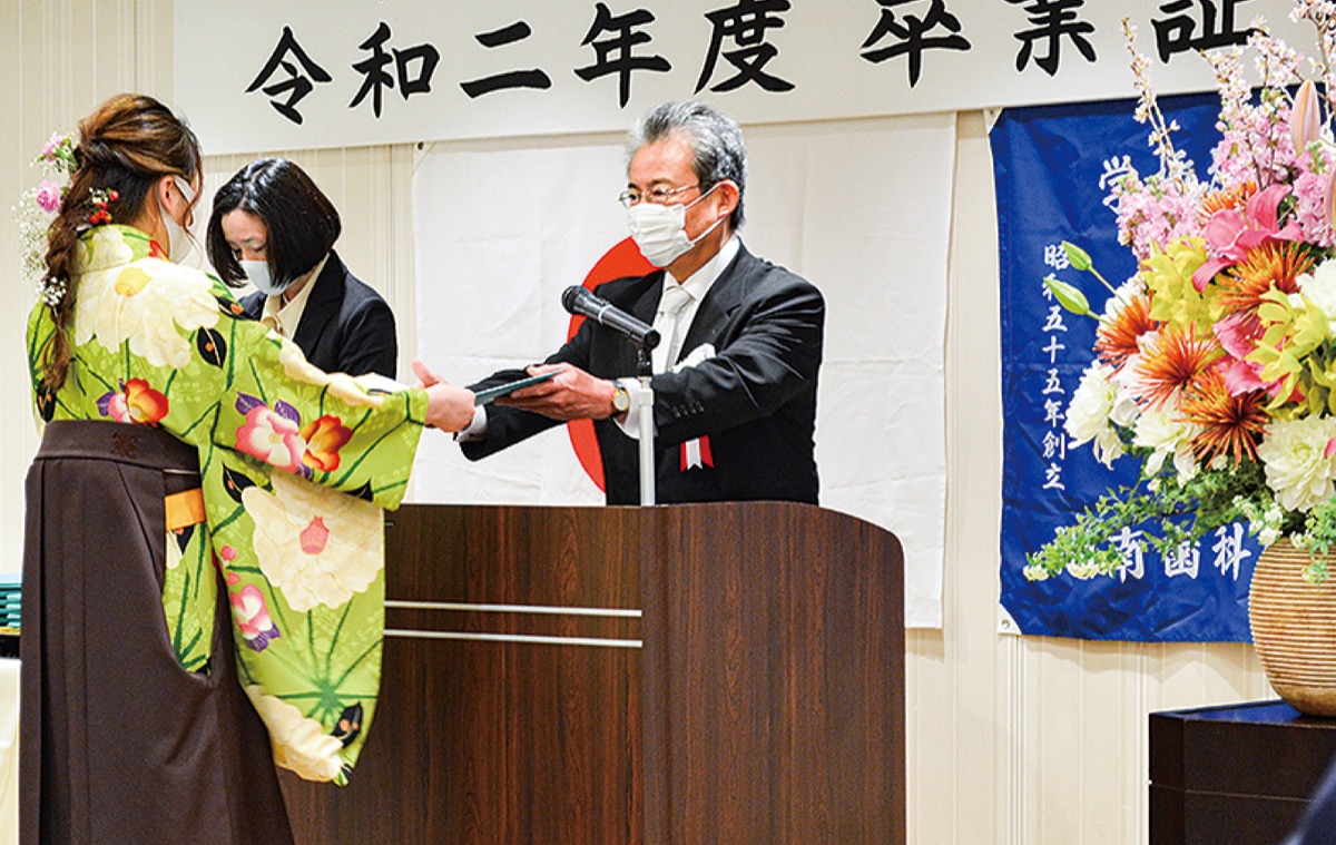 卒業証書を授与する清水理事長