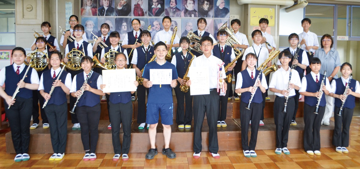 賞状とトロフィーを持つ吹奏楽部の部員ら