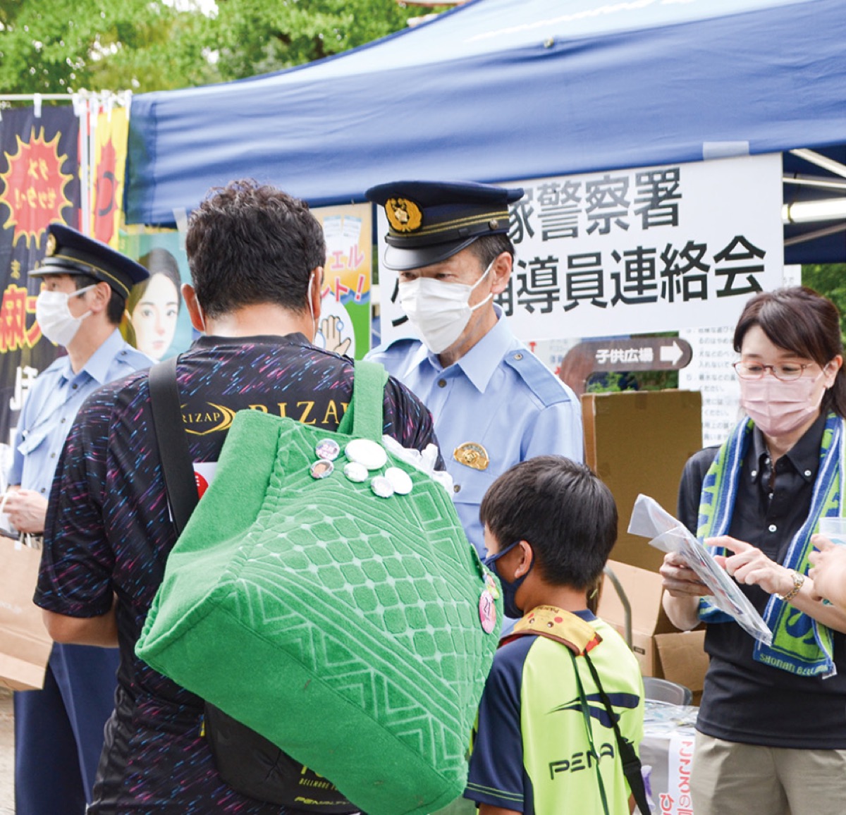 親子連れにビラを配る飯塚署長