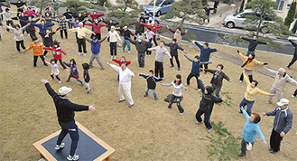40周年記念大会のラジオ体操で体を動かす参加者たち