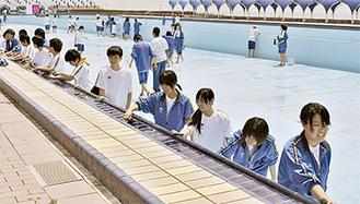 プール清掃をする生徒たち