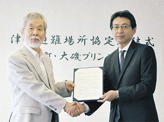 協定書に調印した中崎町長（左）と赤坂統括総支配人