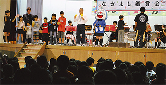 二宮高校吹奏楽部と一緒に演奏する児童と教諭たち