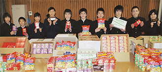 段ボール箱18個分の賞品の菓子を並べて受賞を喜ぶ生徒たち