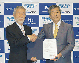 握手する中崎久雄町長（写真左）と中島三千男学長