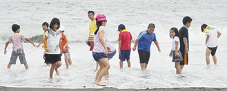 波打ち際で水遊びを楽しむ子どもたち