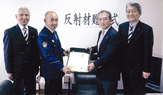 加藤署長（写真左から２番目に）反射材を渡す片岡会長。右端は古澤さん、左端は坂井さん