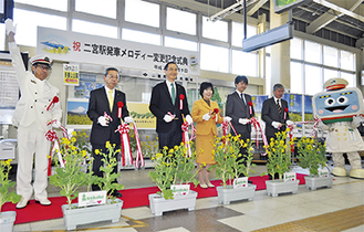 二宮駅の発車メロディー変更を祝ってテープカットをする村田町長（写真左から４番目）と来賓、関係者